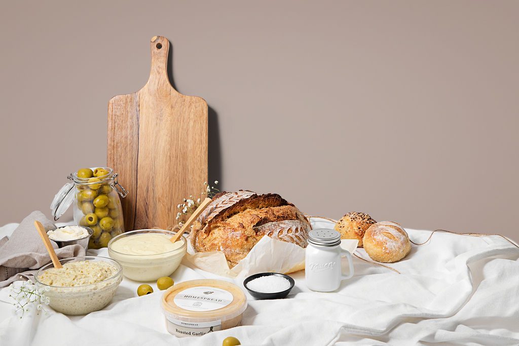 Artisan sourdough loaves and bowls of homemade dips on a linen table